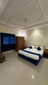 a bedroom with a large bed with blue and white sheets at غيوم ابها - شقق مخدومه in Abha