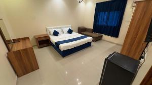 a bedroom with a bed and a tv in it at غيوم ابها - شقق مخدومه in Abha
