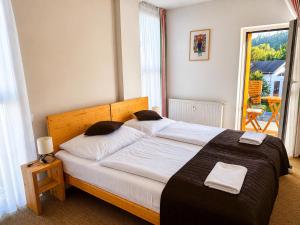 a bedroom with a large bed with white sheets at Aparthotel Belveder in Tatranská Lomnica +91 photos