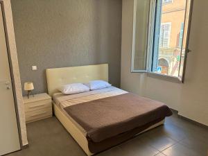 a small bedroom with a bed with a window at Appartements Corte centre in Corte