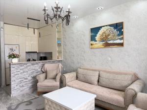 a living room with a couch and two chairs and a table at DS & Sea Suites Batumi in Batumi