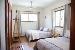 a bedroom with two beds and a window at Casa Velamar in Isla Mujeres