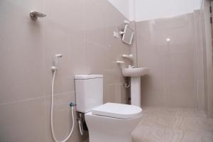 a bathroom with a white toilet and a shower at New Vilard in Tissamaharama
