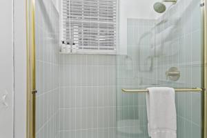 a bathroom with a shower with a glass door at Darling Downtown Renovated Historic Condo Walkable in Savannah