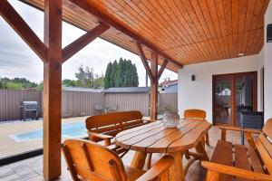 a patio with a wooden table and chairs at BOSzKO HOUSE in Boszkowo