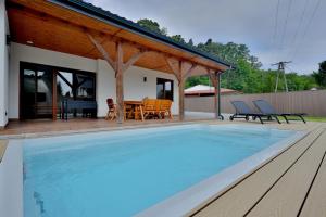 a swimming pool on a deck with a house at BOSzKO HOUSE in Boszkowo