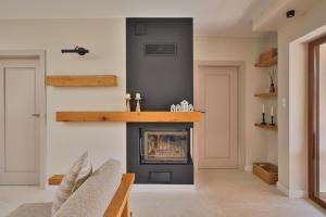 a living room with a fireplace and a shelf on the wall at BOSzKO HOUSE in Boszkowo