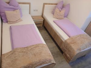 two beds in a room with purple pillows at Lohovo Arena in Bihać