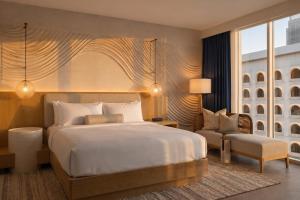 a bedroom with a king sized bed and a chair at Denu Hotel & Spa in Phoenix +26 photos