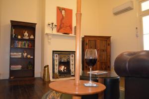 a living room with a glass of wine on a table at Old Parkes Convent in Parkes