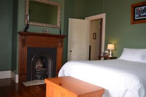 1 dormitorio con 1 cama y chimenea en Old Parkes Convent, en Parkes