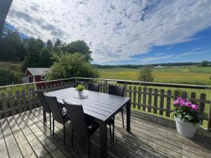 eine Holzterrasse mit einem Holztisch und Stühlen in der Unterkunft Svarteborg Dingle in Dingle + 22 Fotos