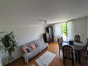 a living room with a couch and a table at Zakątek Pod Lasem in Wydminy