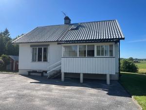 ein weißes Haus mit Dach auf einer Einfahrt in der Unterkunft Svarteborg Dingle in Dingle