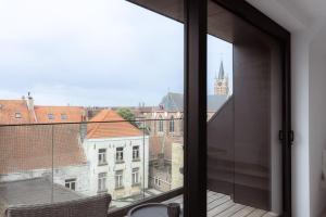 an open window with a view of a building at Sunny duplex penthouse, close to beach, parking in Knokke-Heist