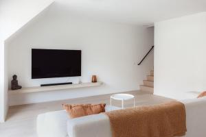 a living room with a white couch and a flat screen tv at Sunny duplex penthouse, close to beach, parking in Knokke-Heist