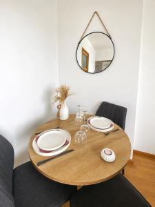a dining room table with a mirror on the wall at La parenthèse in Calais +2 photos