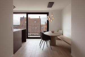 a kitchen and dining room with a table and a window at Sunny duplex penthouse, close to beach, parking in Knokke-Heist