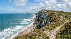 people walking on a cliff next to the ocean at La parenthèse in Calais