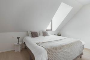 a white bedroom with a large bed in a room at Sunny duplex penthouse, close to beach, parking in Knokke-Heist