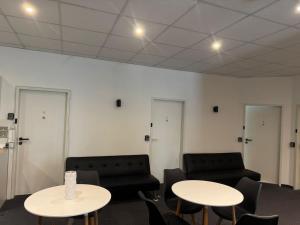 a room with two tables and two couches at Zentrales Boardinghouse MG Rheydt in Mönchengladbach