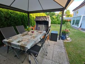 a table and chairs under an umbrella on a patio at Ferienwohnung Ankerplatz Züssow in Züssow