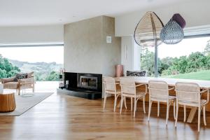 a living room with a table and chairs and a fireplace at Byron Retreat in Coopers Shoot