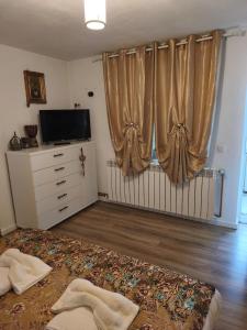 a bedroom with a bed and a television and curtains at Casa Luna in Călimăneşti