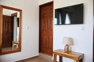 a room with a door and a mirror and a table at Casa Velamar in Isla Mujeres
