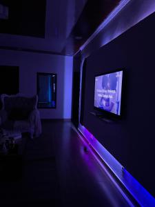 a living room with a tv in a dark room at Cintya Maria in Camama