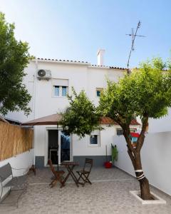 a courtyard in front of a house with a tree at Refúgio Viçoso in Vila Viçosa