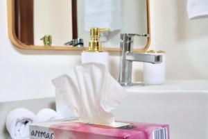 a box of toilet paper sitting on a bathroom sink at Casa Velamar in Isla Mujeres +4 photos