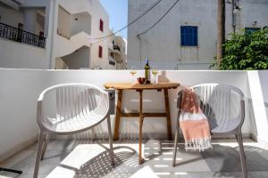 two chairs and a table on a balcony at Eudaimonia in Naxos Chora