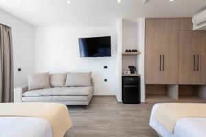 a living room with two beds and a couch at Pantheon Hotel in Kefalos
