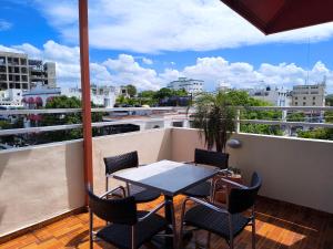 a patio with a table and chairs on a balcony at Hotel La Morada in Santo Domingo +24 photos