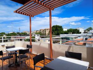 a patio with tables and chairs on a roof at Hotel La Morada in Santo Domingo