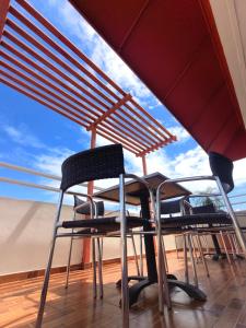 a table and chairs under an umbrella on a roof at Hotel La Morada in Santo Domingo
