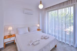 a bedroom with a white bed with towels on it at Hemera Suite in Kaş