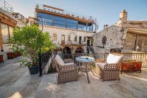 a patio with chairs and a table and a building at Chelebi Cave House in Göreme