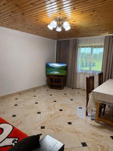 a living room with a television and a tiled floor at Floris in Myta
