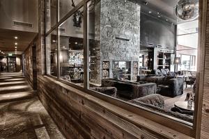 a lobby with a bar with a reflection in a mirror at Grischa - Das Hotel Davos in Davos