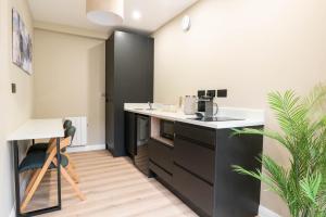 a kitchen with black and white counters and a table at Westport Selfcatering Suites in Westport