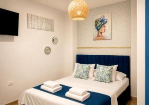 a bedroom with a blue and white bed with towels on it at Hotel Kasaya Grand Deluxe in Santa Marta