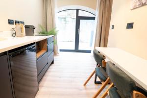 a kitchen with a counter and chairs in a room at Westport Selfcatering Suites in Westport
