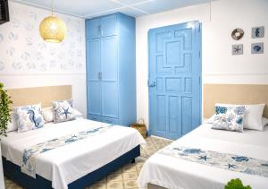 two beds in a room with blue and white at Hotel Kasaya Grand Deluxe in Santa Marta