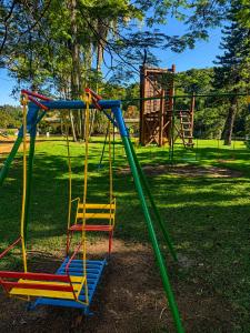 a playground with colorful swings in a park at Hotel Fazenda Morada Do Verde in Campo Limpo