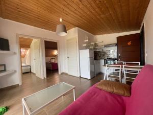 ein Wohnzimmer mit einem lila Sofa und eine Küche in der Unterkunft Orange House in Keramotí