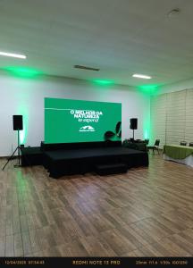 a projection screen in a room with green lights at Hotel Fazenda Morada Do Verde in Campo Limpo