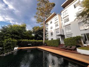 a house with a pond in front of a building at Le Grand Bleu in Koh Samui