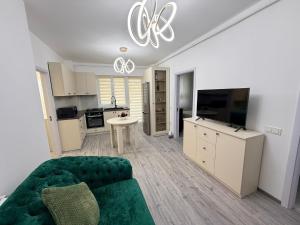 a living room with a green couch and a kitchen at Miry Apartment in Târgu Neamț